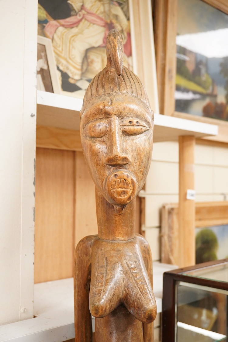 A Fijian carved wood Kava bowl and a West African Dogon fertility figure, 91cm tall